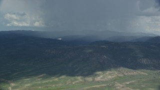 5.5K aerial stock footage of focusing on a Tecnam P2006T airplane as it passes a rainstorm, Wasatch Range, Utah Aerial Stock Footage | AX140_043E