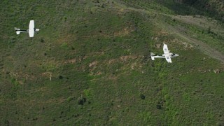 5.5K aerial stock footage of tracking a Tecnam P2006T leading a Cessna over mountains, trees, Wasatch Range, Utah Aerial Stock Footage | AX140_091