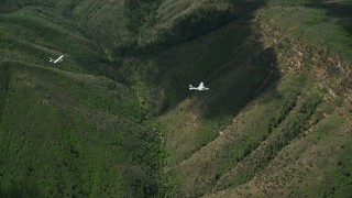 AX140_092E - 5.5K aerial stock footage of flying with a Tecnam P2006T and Cessna over mountains, trees, Wasatch Range, Utah