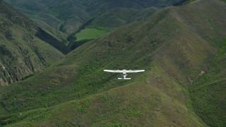 5.5K aerial stock footage of a bird's eye of a Tecnam P2006T in flight over green mountain ridges, Wasatch Range, Utah Aerial Stock Footage | AX140_130E