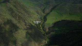 5.5K aerial stock footage focus on a Tecnam P2006T below while flying over green mountain ridges, Wasatch Range, Utah Aerial Stock Footage | AX140_133E