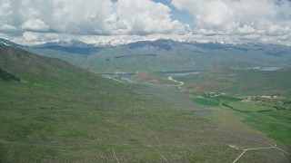 AX140_155E - 5.5K aerial stock footage of Tecnam P2006T flying near reservoir and green mountains, Deer Creek Reservoir, Utah