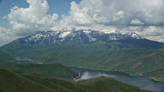 AX140_172E - 5.5K aerial stock footage of homes by Deer Creek Reservoir, and snow-capped Mount Timpanogos, Utah