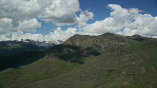 5.5K aerial stock footage of passing by mountain peak, with snowy peaks in the distance, Wasatch Range, Utah Aerial Stock Footage | AX140_187E