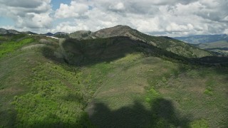 5.5K aerial stock footage of green mountains under partly cloudy skies, Wasatch Range, Utah Aerial Stock Footage | AX140_223E