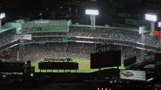 AX141_081E - 5.5K aerial stock footage flying by baseball game, Fenway Park, Boston, Massachusetts, night