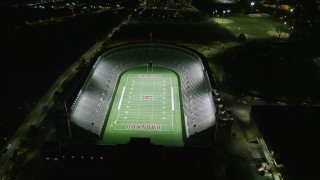 AX141_106E - 5.5K aerial stock footage approaching a well-lit Harvard Stadium, tilt down, Harvard University, Massachusetts, night