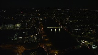 AX141_115E - 5.5K aerial stock footage flying by Doubletree Suites, approaching bridges, Allston, Massachusetts, night