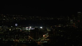 AX141_138E - 5.5K aerial stock footage flying by buildings, skyscrapers, Fenway Park, Boston, Massachusetts, night