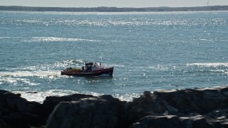 AX142_268E - 5.5K aerial stock footage tracking lobster fishing boat by rock formations, Boston Harbor, Massachusetts