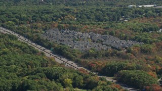 AX143_010E - 5.5K aerial stock footage flying by Pilgrims Highway, condominium complex, autumn, Braintree, Massachusetts