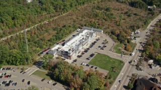 AX143_022E - 5.5K aerial stock footage approaching strip mall in small town, trees, autumn, Cohasset, Massachusetts