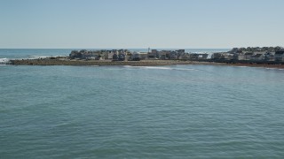 AX143_037E - 5.5K aerial stock footage flying low over ocean, approaching beach, homes, Scituate, Massachusetts