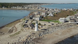 AX143_040E - 5.5K aerial stock footage orbiting Old Scituate Light, beach, oceanfront homes, Scituate, Massachusetts