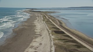 AX143_081 - 5.5K aerial stock footage flying by waves rolling in on a beach, Duxbury, Massachusetts