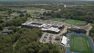 AX143_102 - 5.5K aerial stock footage flying by Plymouth North High School football practice, Plymouth, Massachusetts