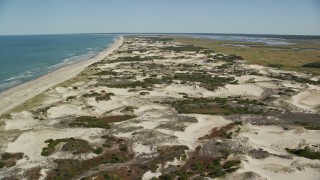 AX143_131E - 5.5K aerial stock footage approaching and flying over a beach and sand dunes, Barnstable, Massachusetts