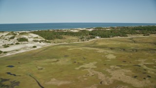 AX143_136E - 5.5K aerial stock footage flying over marshland, by isolated homes, coastal road, Barnstable, Massachusetts