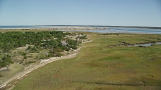 5.5K aerial stock footage of Marshland, coastal road, isolated home, approach Sandy Neck Colony, Cape Cod, Barnstable, Massachusetts Aerial Stock Footage | AX143_141E