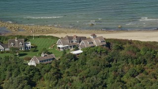 AX143_157E - 5.5K aerial stock footage flying by upscale beachfront homes, Cape Cod, Dennis, Massachusetts