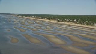 AX143_181E - 5.5K aerial stock footage flying over sand bars, approaching small coastal town, Eastham, Massachusetts