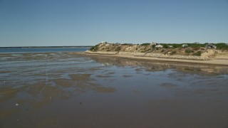 AX143_190E - 5.5K aerial stock footage flying over Cape Cod Bay, approaching homes on the coastline, Wellfleet, Massachusetts