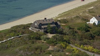 AX143_202E - 5.5K aerial stock footage flying by oceanfront home, Cape Cod, Truro, Massachusetts