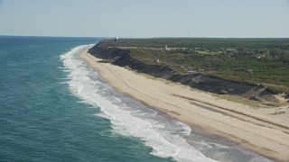 AX144_014 - 5.5K aerial stock footage flying by waves crashing, beach, Highland Light, Cape Cod, Truro, Massachusetts