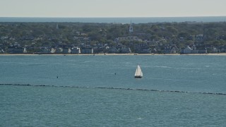 AX144_074 - 5.5K aerial stock footage flying by small island town, sailboats on water, Nantucket, Massachusetts