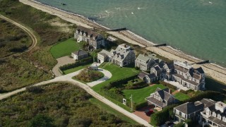 AX144_106 - 5.5K aerial stock footage flying by beachfront upscale homes, tilt down, Nantucket, Massachusetts