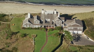 AX144_107 - 5.5K aerial stock footage flying by upscale beachfront homes, tilt down, Nantucket, Massachusetts