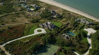 AX144_112 - 5.5K aerial stock footage approaching upscale beachfront homes, tilting down, Nantucket, Massachusetts