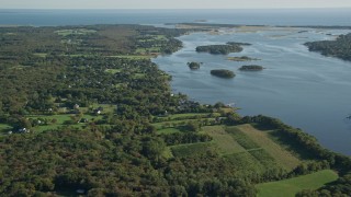 AX144_216 - 6k aerial stock footage flying by rural coastal neighborhood, tiny islands in bay, Westport, Massachusetts