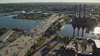 AX145_080E - 6k aerial stock footage approaching Providence River Bridge, power plant, smoke stacks, Providence, Rhode Island