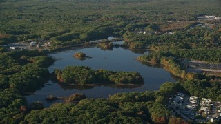 6k aerial stock footage flying by Turnpike Lake, green trees, autumn, Plainville, Massachusetts Aerial Stock Footage | AX145_105