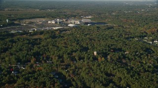 6k aerial stock footage flying by Gillette Stadium, dense trees, autumn, Foxborough, Massachusetts Aerial Stock Footage | AX145_110