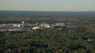 6k aerial stock footage flying by Gillette Stadium, dense trees, autumn, Foxborough, Massachusetts Aerial Stock Footage | AX145_112E