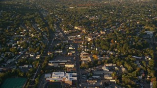 AX146_006E - 6k aerial stock footage flying over Hyde Park Avenue near church, school and homes, autumn, Hyde Park, Massachusetts, sunset