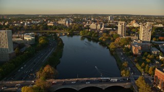 AX146_018E - 6k aerial stock footage flying over Charles River, approach Harvard University, Massachusetts, sunset