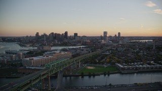 AX146_097 - 6k aerial stock footage flying by Tobin Memorial Bridge, skyline, Charlestown, Massachusetts, sunset