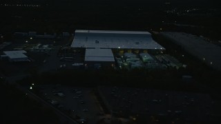 6k aerial stock footage flying by a warehouse, Westwood, Massachusetts, night Aerial Stock Footage | AX146_166