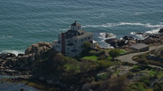 6K aerial stock footage approaching oceanfront home on rocky shoreline, Gloucester, Massachusetts Aerial Stock Footage | AX147_107