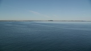 AX147_135 - 6K aerial stock footage flying over water toward a coastline, Ipswich, Massachusetts