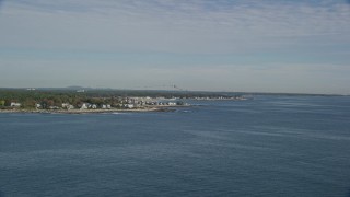 AX147_164 - 6K aerial stock footage approaching a coastal town and track flock of birds toward water, autumn, Rye, New Hampshire