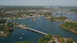 6K aerial stock footage flying over a small bridge toward a coastal town in autumn, Portsmouth, New Hampshire Aerial Stock Footage | AX147_173