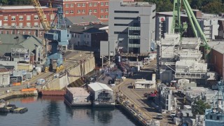 6K aerial stock footage flying by a submarine in a naval shipyard, Kittery, Maine Aerial Stock Footage | AX147_188