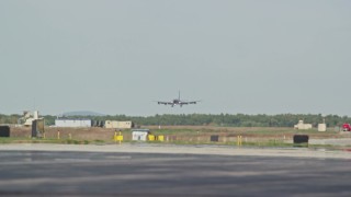 AX147_210E - 6K aerial stock footage tracking a military plane, Portsmouth International Airport, New Hampshire