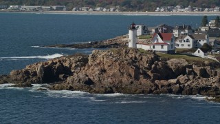 6K aerial stock footage orbiting Cape Neddick Light, coastal town, autumn, York, Maine Aerial Stock Footage | AX147_239