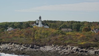 AX147_306 - 6K aerial stock footage flying away from coastal town, Cape Elizabeth Light, autumn, Cape Elizabeth, Maine