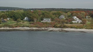 AX147_317 - 6K aerial stock footage flying by oceanfront homes, Cushing Island, autumn, Portland, Maine